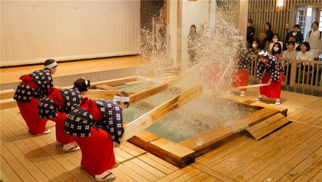 草津温泉独特的“时间浴”沐浴法：为了降低温度，用一块长板搅拌池内的温泉，一边搅拌，一边唱歌。
