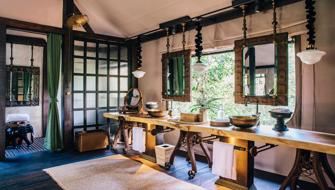 木质洗漱台、复古的悬挂式镜子、镀金的金属洗脸盆，彰显房间的丛林格调。
