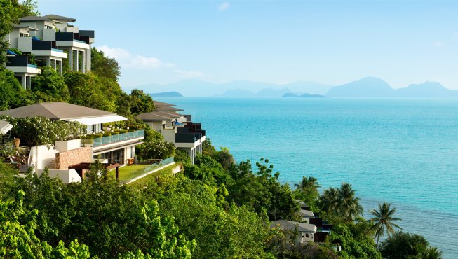 酒店掩映在郁郁葱葱的热带作物中，靠山面海。