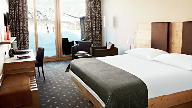 透过Nira Alpina酒店客房的全景窗可以看到外面雪白壮丽的阿尔卑斯山景。