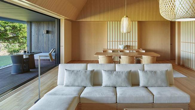 客房内的白色橡木咖啡桌、沙发和扶手椅与大地色织物的色调相得益彰。

