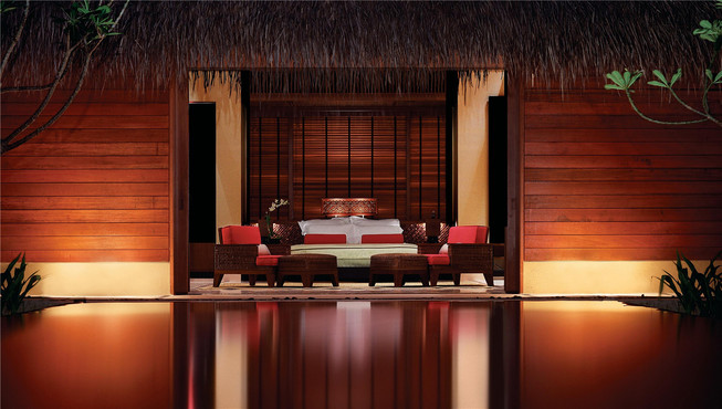 带私人泳池的海滩别墅设有延伸至海边的户外用餐区和热带树木遮荫的沙发床。