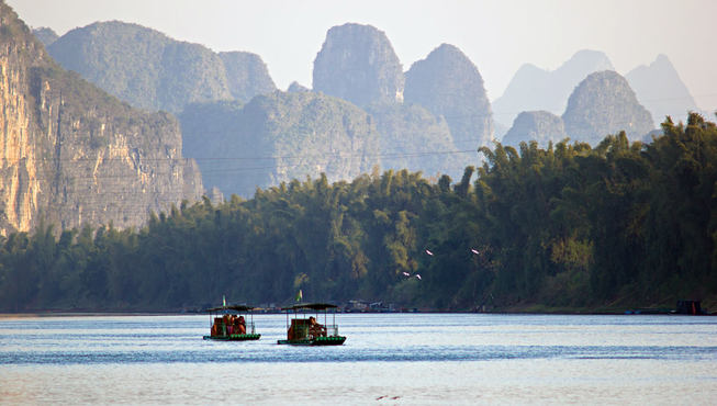 乘坐竹筏漂过澄净的河水，感受漓江之美。