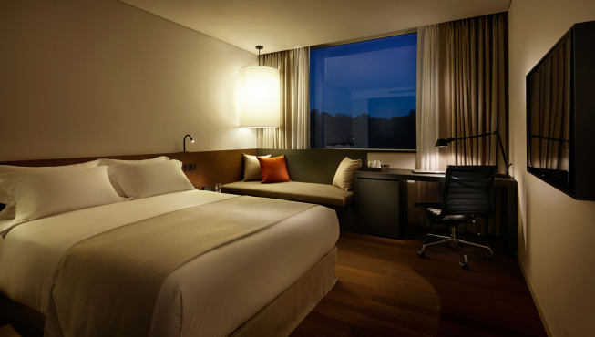 酒店客房，宽敞舒适的大床，能俯瞰首尔的城市景观。
