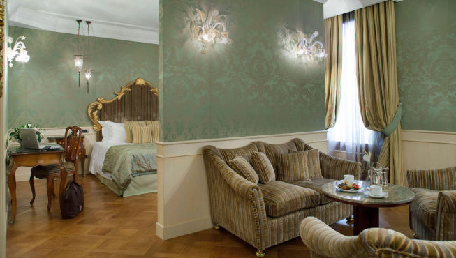 柔和的天花板镶嵌着纯手工制作的威尼斯经典大吊灯，墙面则被柔软的丝织物覆盖