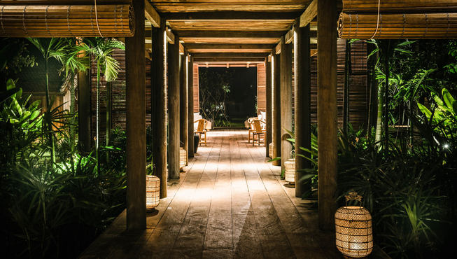 酒店的长廊休息区，周边围绕着茂密的植被，私密而清幽