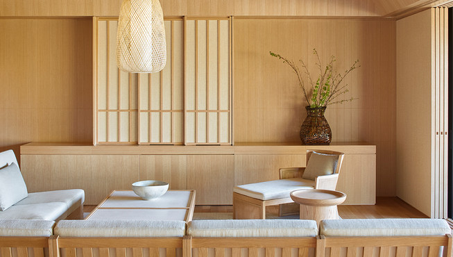 定制家具确保建筑和设计之间完美平衡，白色橡木咖啡桌、沙发和扶手椅与大地色织物的色调相得益彰，饰品的数量被精简至最低，与日本室内设计传统相契合，以免扰乱注意力