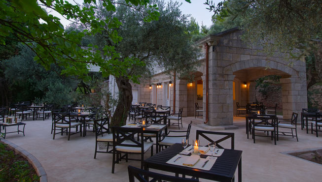 坐在户外的露天餐厅享用美食，海风微咸，享受惬意时光。