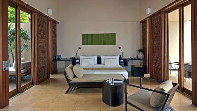 宽敞的卧室以现代风格的木制家具为主，配以赤陶瓷砖的地板，