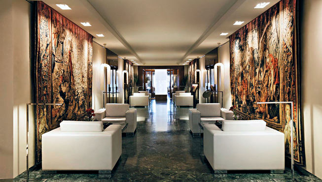 酒店大堂，白色的皮质沙发与墙面上的多彩壁画行程鲜明的对比