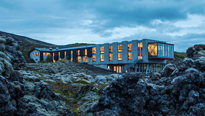 酒店拥有狭长的外型，不规则的立柱与开窗，彷佛有生命般盘踞在大岩石之上。