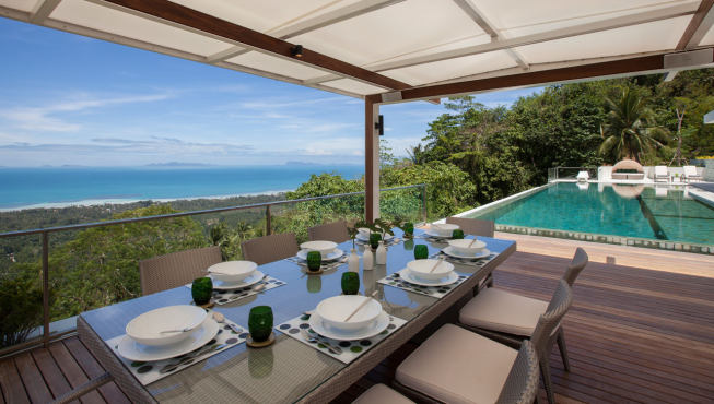 别墅被被热一个十人座的餐桌摆放在泳池边的宽阔露台上，享受在无边无际的海景中用餐的美妙体验。